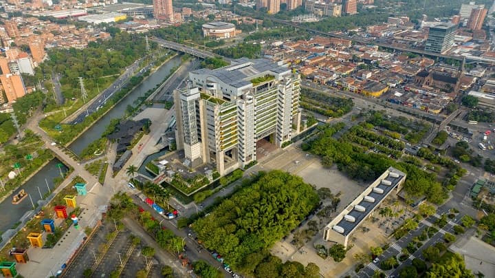 Vista aérea de un moderno edificio rodeado de vegetación y áreas urbanas