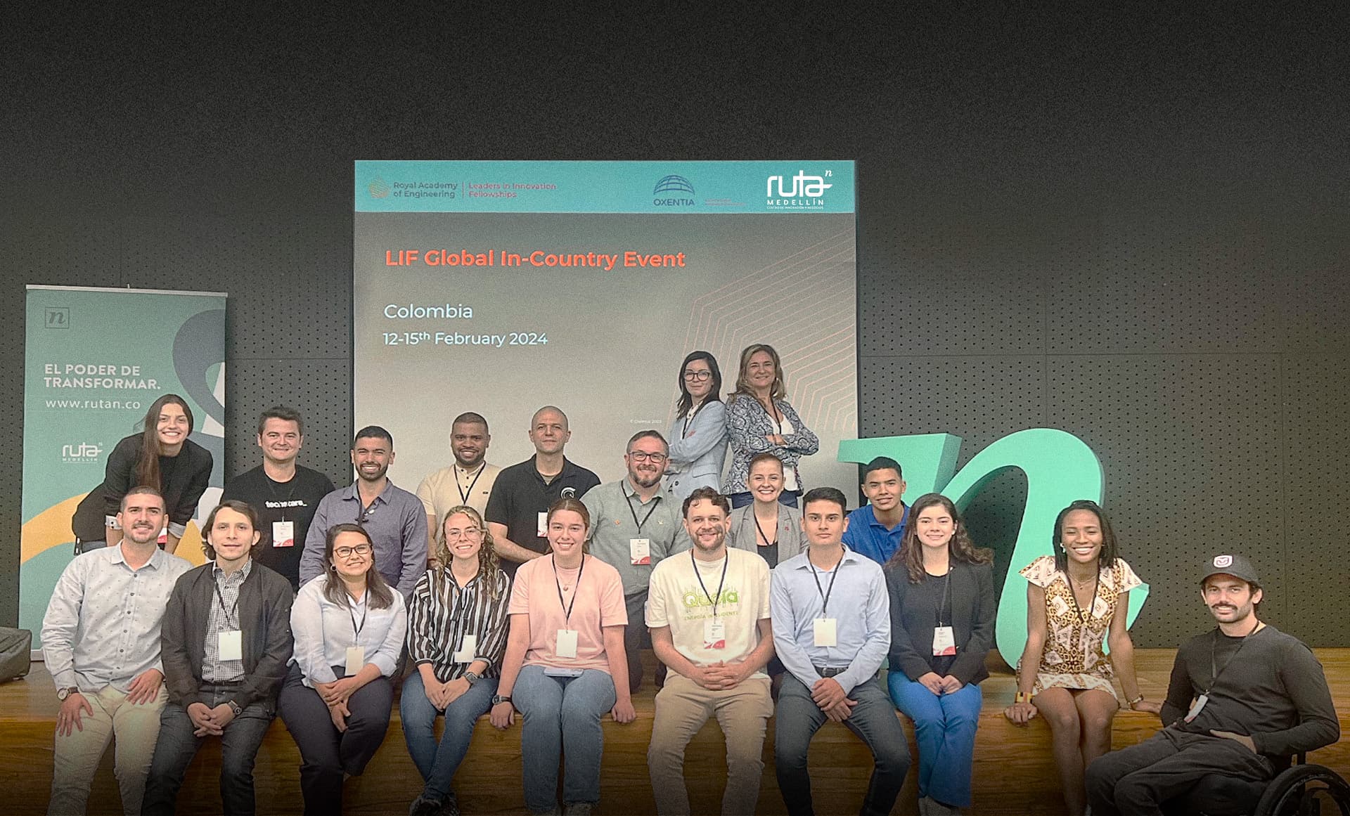 Grupo de personas posando en un evento llamado 'LIF Global In-Country Event' en Colombia, con carteles de fondo y decoraciones.